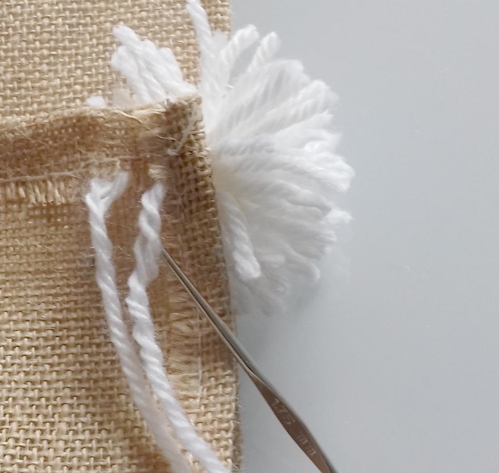 DIY : assembler avec un crochet le pompon en pure laine sur la toile de jute, fait main, slow design, deco naturelle